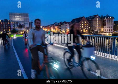 Radfahrer auf der Inderhavnsbroen Fahrrad- und Fußwegsbrücke, über den Hafen, nachts, in Nyhavn, Kopenhagen, gilt als die Fahrradhauptstadt von Stockfoto