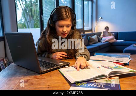 Homeschooling, 2 Mädchen, Schwestern, 11 Jahre alt, zu Hause lernen, Home Learning, Unterricht zu Hause, Fernunterricht, Chat mit Lehrern und Klassenkameraden Stockfoto