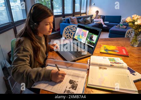 Homeschooling, 2 Mädchen, Schwestern, 11 Jahre alt, zu Hause lernen, Home Learning, Unterricht zu Hause, Fernunterricht, Chat mit Lehrern und Klassenkameraden Stockfoto