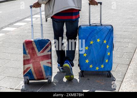 Symbolisches Bild Brexit, Mann mit 2 Trolley-Koffern, einer mit Union Jack, und Europa-Flaggendesign Stockfoto