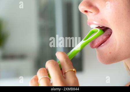 Mundgeruch, Vorbeugung durch Reinigung der Zunge mit einer Zungenbürste Stockfoto