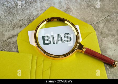 Persönliche Meinungen Vorurteile. VORSPRUNG durch eine Lupe auf einem senfeinfarbenen Umschlag Stockfoto