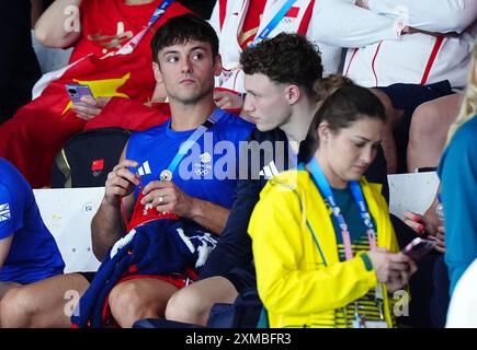 Der britische Tom Daley strickt, während er am ersten Tag der Olympischen Spiele in Paris 2024 in Frankreich das 3-m-Springboard-Finale der Frauen im Aquatics Centre ansieht. Bilddatum: Samstag, 27. Juli 2024. Stockfoto
