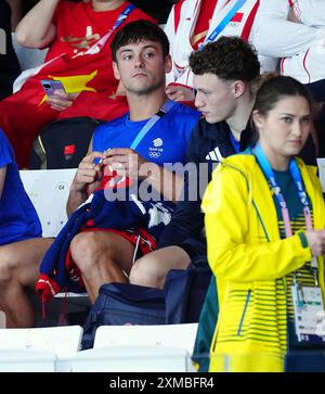 Der britische Tom Daley strickt, während er am ersten Tag der Olympischen Spiele in Paris 2024 in Frankreich das 3-m-Springboard-Finale der Frauen im Aquatics Centre ansieht. Bilddatum: Samstag, 27. Juli 2024. Stockfoto