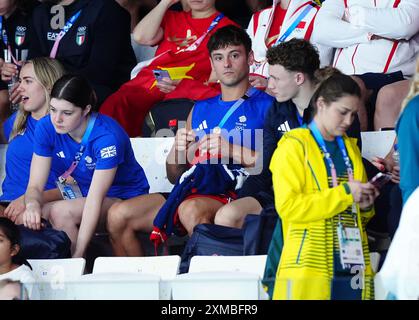 Der britische Tom Daley strickt, während er am ersten Tag der Olympischen Spiele in Paris 2024 in Frankreich das 3-m-Springboard-Finale der Frauen im Aquatics Centre ansieht. Bilddatum: Samstag, 27. Juli 2024. Stockfoto