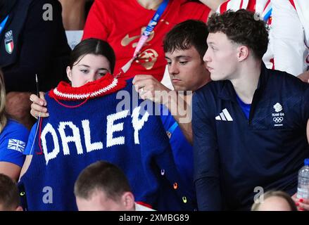 Der britische Tom Daley strickt, während er am ersten Tag der Olympischen Spiele in Paris 2024 in Frankreich das 3-m-Springboard-Finale der Frauen im Aquatics Centre ansieht. Bilddatum: Samstag, 27. Juli 2024. Stockfoto