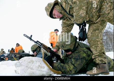 Ein Offizier, der die Rekruten des Schießens mit der Maschinenpistole eindringt. Militärbereich, Ukraine. Februar 2019. Militäranlage in Novo-Petrivtsi, Ukraine Stockfoto