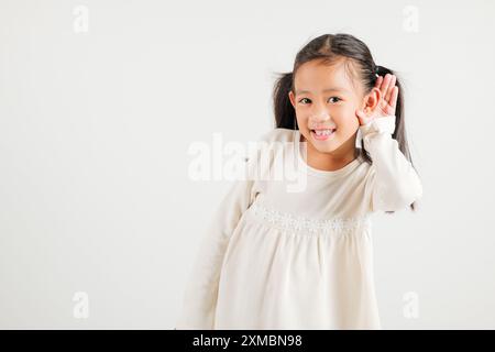 Portrait Asiatisches kleines Kind lächelnd hörend hörend Tratsch mit Aufmerksamkeit mit der Hand Stockfoto