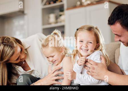 Heim, Familie und Kinder mit lustigem Kitzeln für lustige Bindungen, Liebe und verspieltes Wochenende. Sofa, Mutter und Vater mit Töchtern im Leben Stockfoto