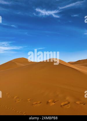 Fußspuren im Sand der Wüstendünen von Erg chebbi vor blauem Himmel, Marokko Stockfoto