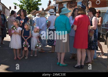 Treffen am Kreuz, Mitglieder der Nether Stowey Female Friendly Society am Club Day. Die Mutter und ihre Töchter, die Blumenmädchen, werden alle zum Grab des Gründers, des Geschäftsmannes Tom Poole, in der St. Marys Church gehen. Nether Stowey, Somerset, England, 21. Juni 2014. GROSSBRITANNIEN 2010ER JAHRE HOMER SYKES Stockfoto