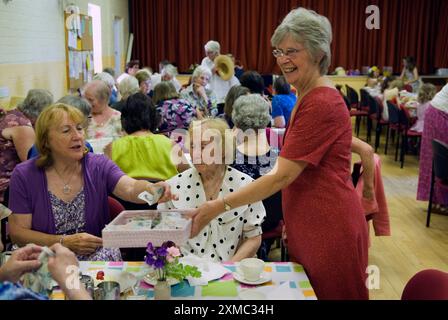 Village Hall, Cream Tea. The Nether Stowey Female Friendly Society; The Womens Walk on Club Day. Ein Mitglied übernimmt die Kosten für Cream Tea, die 2014 £ 5,00 betragen. Eine Frau zahlt mit einem 5,00-Pfund-Schein. Ein Tablett mit fünf Pfund Scheinen. Nether Stowey, Somerset, England 21. Juni, UK 2010s HOMER SYKES Stockfoto