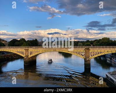 Richmond Railway Bridge, von der Twickenham Bridge aus gesehen, in der Abenddämmerung mit blauem Himmel und Sonne / blauem Himmel und Sonne. Richmond upon Thames ist im Hintergrund. UK. (138) Stockfoto