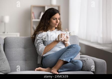 Hispanische Frau, die ein modernes Smartphone benutzt, verbringe Freizeit im Internet Stockfoto