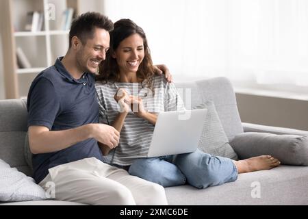 Glückliche Frau und Mann, die zu Hause ein Notebook benutzen Stockfoto