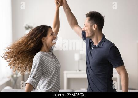 Glückliches romantisches Paar, das sich verliebt hat und zu Hause tanzen kann Stockfoto