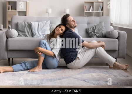 Junge nachdenkliche Lateinpaare, die auf dem Boden sitzen Stockfoto