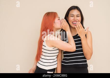 Porträt von zwei schönen asiatischen Frauen im Freien Studio, aufgenommen vor unauffälligem Hintergrund Stockfoto