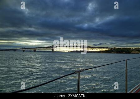 Auckland Harbour, Neuseeland - Auckland Harbour Bridge bei Sonnenuntergang, von einer Yacht im Hafen von Waitematā aus gesehen Stockfoto