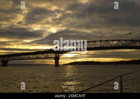 Auckland Harbour, Neuseeland - Auckland Harbour Bridge bei Sonnenuntergang, von einer Yacht im Hafen von Waitematā aus gesehen Stockfoto