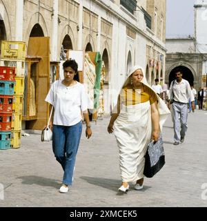 Tunis, Tunesien. Tunesische Frauen, moderne und traditionelle Kleidungsstücke nebeneinander. Stockfoto