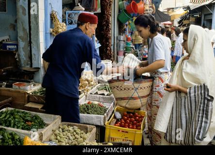 Tunis, Tunesien.  Gemüsehändler.  Tunesische Frauen mit modernem und traditionellem Stil des Kleides. Stockfoto