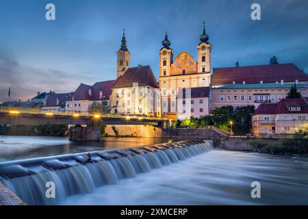 Steyr, Österreich. Blick auf Saint. Michaelskirche und Brücke über den Steyr-Fluss in der Abenddämmerung Stockfoto