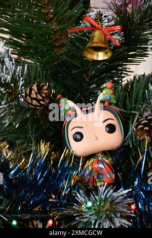 Funko Pop Actionfigur von Mantis aus Marvel Superheldenfilm Guardians of the Galaxy. Spielzeug, das auf einem Weihnachtsbaumzweig steht, mit Ornamenten, Girlande. Stockfoto