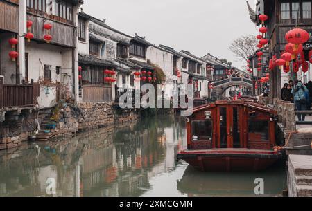 Suzhou, China - 01. Januar 2019: Traditionelles Holzboot, das an historischen Kanälen in einer bezaubernden chinesischen Wasserstadt verankert ist. Stockfoto