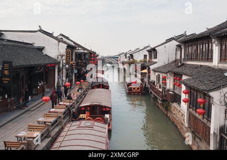 Suzhou, China - 01. Januar 2019: Traditionelle Holzboote, die an historischen Kanälen in einer bezaubernden chinesischen Wasserstadt vertäut sind. Stockfoto