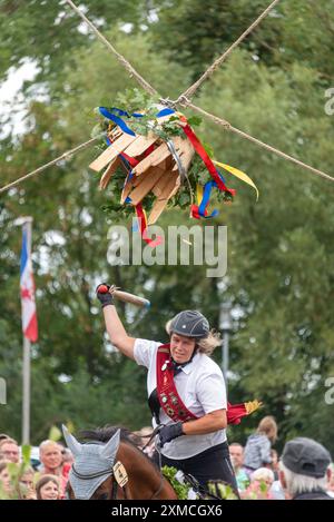 Klockenhagen, Deutschland. Juli 2024. Eine Pferdefrau schlägt eine Heringsboje mit einem Schläger. Sie konkurriert mit 15 weiteren Fahrern um mehrere Königstitel beim traditionellen Fassschlagen in Klockenhagen. 2017 wurde die weit verbreitete Praxis des Fass-Schlagens auf der Ostsee in die Liste des immateriellen Kulturerbes der UNESCO aufgenommen. Quelle: Stephan Schulz/dpa/Alamy Live News Stockfoto