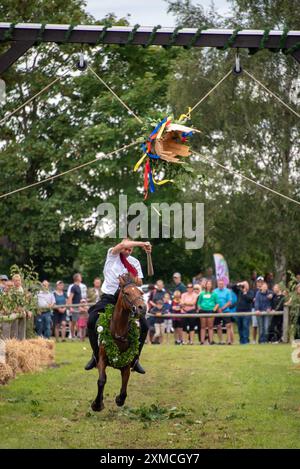 Klockenhagen, Deutschland. Juli 2024. Ein Reiter schlägt eine Heringsboje mit einem Schläger. Er konkurriert mit 15 weiteren Fahrern um mehrere Königstitel beim traditionellen Fassschlagen in Klockenhagen. 2017 wurde die weit verbreitete Praxis des Fass-Schlagens auf der Ostsee in die Liste des immateriellen Kulturerbes der UNESCO aufgenommen. Quelle: Stephan Schulz/dpa/Alamy Live News Stockfoto
