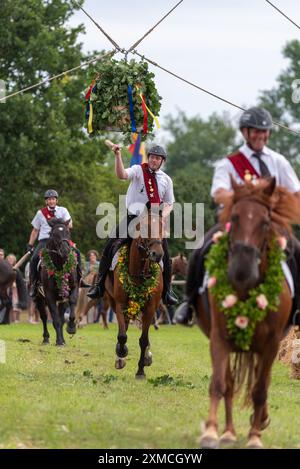 Klockenhagen, Deutschland. Juli 2024. Die Fahrer versuchen, Holzstücke aus einem Heringsfass mit einem Schläger zu schlagen. Sie konkurrieren um mehrere Königstitel beim traditionellen Boje-Töten in Klockenhagen. 2017 wurde die weit verbreitete Praxis des Fass-Schlagens auf der Ostsee in die Liste des immateriellen Kulturerbes der UNESCO aufgenommen. Quelle: Stephan Schulz/dpa/Alamy Live News Stockfoto