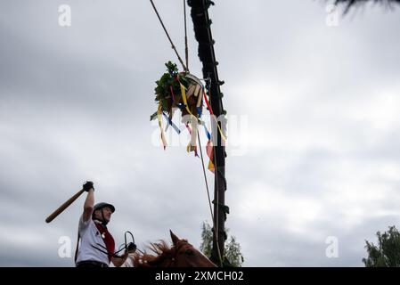 Klockenhagen, Deutschland. Juli 2024. Ein Reiter schlägt eine Heringsboje mit einem Schläger. Er konkurriert mit 15 weiteren Fahrern um mehrere Königstitel beim traditionellen Fassschlagen in Klockenhagen. 2017 wurde die weit verbreitete Praxis des Fass-Schlagens auf der Ostsee in die Liste des immateriellen Kulturerbes der UNESCO aufgenommen. Quelle: Stephan Schulz/dpa/Alamy Live News Stockfoto