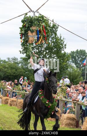 Klockenhagen, Deutschland. Juli 2024. Eine Pferdefrau schlägt eine Heringsboje mit einem Schläger. Sie konkurriert um mehrere Königstitel beim traditionellen Boje-Töten in Klockenhagen. 2017 wurde die weit verbreitete Praxis des Fass-Schlagens auf der Ostsee in die Liste des immateriellen Kulturerbes der UNESCO aufgenommen. Quelle: Stephan Schulz/dpa/Alamy Live News Stockfoto