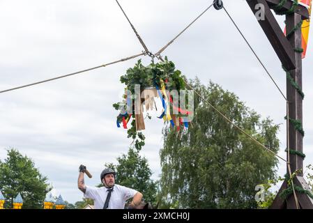 Klockenhagen, Deutschland. Juli 2024. Ein Reiter schlägt eine Heringsboje mit einem Schläger. Er konkurriert mit 15 weiteren Fahrern um mehrere Königstitel beim traditionellen Fassschlagen in Klockenhagen. 2017 wurde die weit verbreitete Praxis des Fass-Schlagens auf der Ostsee in die Liste des immateriellen Kulturerbes der UNESCO aufgenommen. Quelle: Stephan Schulz/dpa/Alamy Live News Stockfoto