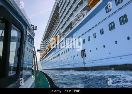 Nizza, Frankreich: Hafenpilotenboot nähert sich der riesigen MEERESHYMNE der Royal Caribbean, um den Seefahrer in Villefranche sur Mer zu besteigen. Ein einzigartiger Zwischenstopp für das größte Kreuzfahrtschiff dieses Jahr im kleinen Hafen der französischen Riviera. Nach der Sommersaison sollte das beeindruckende Schiff im Rahmen einer Umschichtung von Europa nach Singapur durch den Suez-Kanal segeln, aber nach Spannungen am Roten Meer und Drohungen mit Houthi-Raketen auf Schiffe, stattdessen wird sie ohne Passagier die Südspitze Afrikas erkunden, um Dubai und Asien zu erreichen. Quelle: Kevin Izorce/Alamy Live News Stockfoto