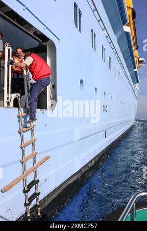 Nizza, Frankreich: Hafenpilotenboot nähert sich der riesigen MEERESHYMNE der Royal Caribbean, um in Villefranche sur Mer von Bord zu gehen. Ein einzigartiger Zwischenstopp für das größte Kreuzfahrtschiff dieses Jahr im kleinen Hafen der französischen Riviera. Nach der Sommersaison sollte das beeindruckende Schiff im Rahmen einer Umschichtung von Europa nach Singapur durch den Suez-Kanal segeln, aber nach Spannungen am Roten Meer und Drohungen mit Houthi-Raketen auf Schiffe, stattdessen wird sie ohne Passagier die Südspitze Afrikas erkunden, um Dubai und Asien zu erreichen. Quelle: Kevin Izorce/Alamy Live News Stockfoto