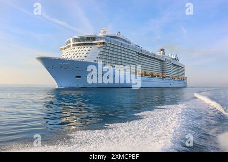 Nizza, Frankreich : die riesige HYMNE der Königlichen Karibik VON DEN MEEREN in der Schifffahrt vom Pilotenboot in Villefranche sur Mer aus gesehen. Ein einzigartiger Zwischenstopp für das größte Kreuzfahrtschiff dieses Jahr im kleinen Hafen der französischen Riviera. Nach der Sommersaison sollte das beeindruckende Schiff im Mittelmeer und dann durch den Suez-Kanal segeln, als Teil einer Umschichtung von Europa in den neuen Heimathafen in Singapur, aber nach Spannungen am Roten Meer und Drohungen mit Houthi-Raketenangriffen auf Schiffe, stattdessen wird sie ohne Passagier die Südspitze Afrikas erkunden, um Dubai und Asien zu erreichen. Quelle: Kevin Izorce/Alamy Live News Stockfoto