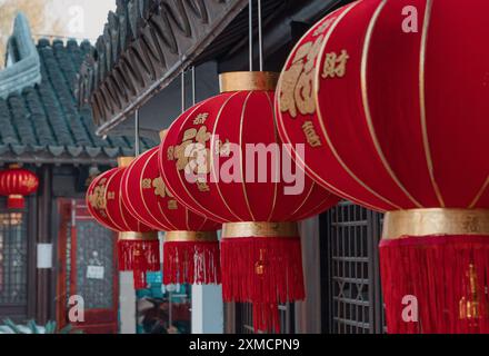 Suzhou, China - 01. Januar 2019: Leuchtende rote Laternen hängen während der Festivalsaison elegant unter einem traditionellen Dach im chinesischen Innenhof Stockfoto