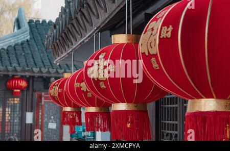 Suzhou, China - 01. Januar 2019: Leuchtende rote Laternen hängen während der Festivalsaison elegant unter einem traditionellen Dach im chinesischen Innenhof Stockfoto