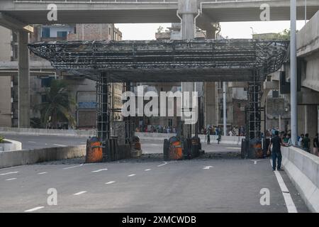 Dhaka, Bangladesch. Juli 2024. Die Menschen schauen auf die toll plaza der erhöhten Schnellstraße, die von einem Mob während der Auseinandersetzungen nach Studentenprotesten gegen staatliche Jobquoten in Brand gesetzt wurde. (Foto: Piyas Biswas/SOPA Images/SIPA USA) Credit: SIPA USA/Alamy Live News Stockfoto