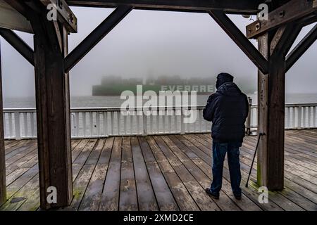 Dicker Nebel im Winter, der über der Mündung der Elbe in die Nordsee hängt, Containerschiff Ever Arm, von der Elbe nach Rotterdam, Aussichtspunkt Alte Stockfoto