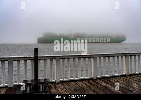 Dicker Nebel im Winter, der über der Mündung der Elbe in die Nordsee hängt, Containerschiff Ever Arm, von der Elbe nach Rotterdam, Aussichtspunkt Alte Stockfoto