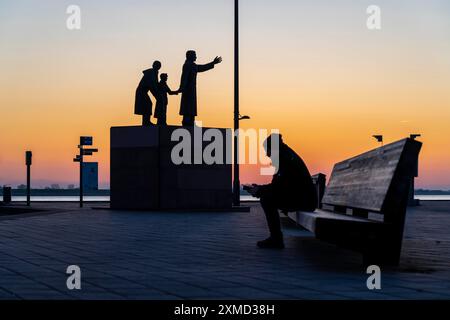 Das Emigrantendenkmal, die Emigranten, am Willy-Brand-Platz, an der Seebaederkaje, Sonnenuntergang über der Wesermündung mit in Bremerhaven, Bremen, Deutschland Stockfoto