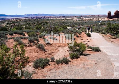 Moab, Utah, USA - 22. April 2017: Besucher gehen auf einem Wanderweg zu den Windows im Arches National Park Stockfoto