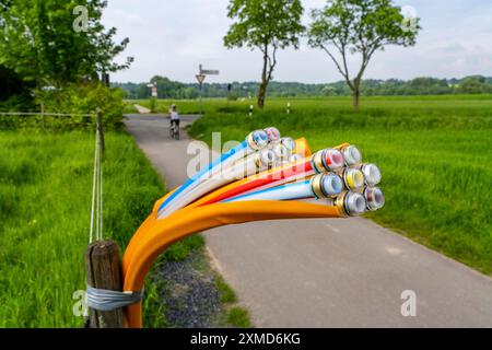 Glasfaserkabel, frisch auf einem Feldweg verlegt, in einem Fahrerlager, warten auf weitere Erweiterung, Erweiterung und Bereitstellung von Hochgeschwindigkeits-Internet auf dem Land Stockfoto