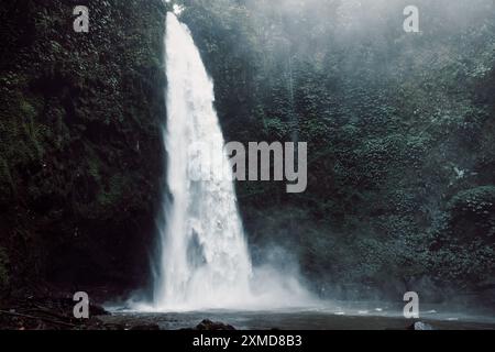 Einer der malerischsten Wasserfälle in Bali. Nungnung Wasserfall mit kräftigem Fluss. Stockfoto