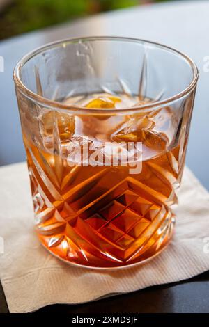 Ein Glas Whiskey mit einer Kirsche oben und einer Orangenscheibe innen. Das Getränk ist ein traditionelles altmodisches manhattan. Stockfoto