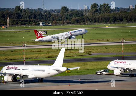 Flughafen Düsseldorf, Turkish Airlines Airbus A321 beim Start, Eurowings Airbus in Parkposition Stockfoto